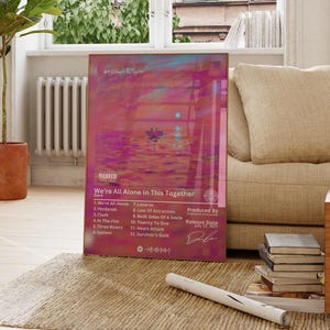 Può includere: Un poster rettangolare che mostra un vibrante tramonto rosa e viola sull'acqua con la sagoma di una piccola barca. Il testo recita We're All Alone In This Together, elencando tracce tra cui We're All Alone, Lazarus, Verdansk e altre ancora.