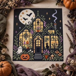 May include: A cross-stitch embroidery on beige fabric depicting a dark house with yellow-lit windows, a full moon with bats, a ghost, a jack-o'-lantern, and a black cat silhouette. The scene includes purple flowers, green vines, and a chimney with smoke.