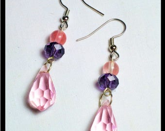 May include: A pair of dangle earrings with pink and purple crystal beads and teardrop-shaped pink crystal pendants.