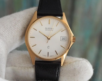 Zegarek kwarcowy Alpina Sea-Strong – koperta w kolorze złotym o średnicy 33 mm, wyprodukowany w Szwajcarii, w stanie miętowym, nienoszony, z nową baterią