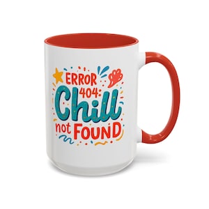May include: A white ceramic mug with a bright red interior and handle. The exterior features a colorful graphic with the text "ERROR 404: Chill not FOUND" in blue and red, surrounded by small yellow stars, red shapes, and blue decorative accents.