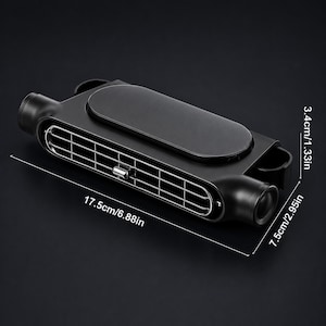 Puede incluir: Un ventilador de ventilaci&oacute;n para coche negro de forma rectangular con una rejilla central, un panel superior liso y componentes laterales cil&iacute;ndricos. El dispositivo mide 17,5 cm de largo, 7,5 cm de ancho y 3,4 cm de alto seg&uacute;n las etiquetas.