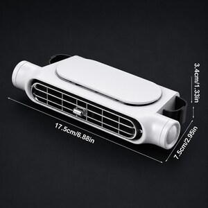 Puede incluir: Un ventilador de ventilaci&oacute;n port&aacute;til blanco y negro con una rejilla rectangular y un panel superior liso. El dispositivo mide 17,5 cm de largo, 7,5 cm de ancho y 3,4 cm de alto, con una perilla de ajuste central de color plateado.
