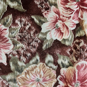 May include: Close-up of a floral fabric with large, stylized flowers in shades of pink, peach, and cream. The background features a mix of dark burgundy and olive green, creating a vintage aesthetic. The fabric has a textured appearance.