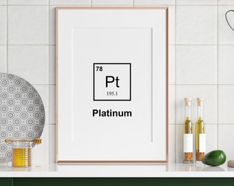 May include: A framed print of the periodic table element Platinum (Pt) with the atomic number 78 and atomic weight 195.1. The print is hanging on a white tiled wall in a kitchen setting.