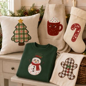 Könnte beinhalten: Eine Sammlung von weihnachtlichen Artikeln, bestehend aus einem beigen Kissen mit kariertem Weihnachtsbaum, einer beigen Schürze mit roter Kakaotasse, einem beigen Strumpf mit roter Zuckerstange, einem dunkelgrünen Sweatshirt mit Schneemann und einem beigen Handtuch mit Lebkuchenmann.