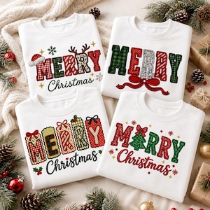 May include: Four white crewneck sweatshirts featuring festive holiday graphics. Each shirt displays the text Merry Christmas in various patterned fonts, including plaid, stripes, and polka dots, accented with reindeer antlers, bows, and trees.