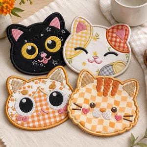 以下が含まれることがあります： 猫の形をした刺繍入りコースター4枚セット。星柄の黒猫、花柄とチェック柄の白猫、オレンジ色のギンガムチェックと花柄の白猫、ハートの頬をしたオレンジ色の市松模様の猫という、それぞれ異なるデザインが施されています。