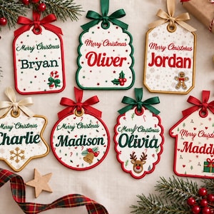 Könnte beinhalten: Sieben personalisierte Weihnachtsschmuckstücke in verschiedenen Formen mit dem Text Merry Christmas und Namen wie Bryan, Oliver, Jordan, Charlie, Madison, Olivia und Maddie, verziert mit festlichen Symbolen wie Zuckerstangen, Stechpalmen und Rentieren.