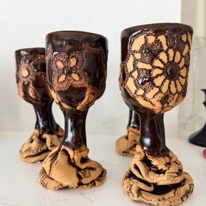 Copa de cerámica vintage hecha a mano con esmalte marrón con efecto de goteo y textura de encaje. Estilo brutalista.