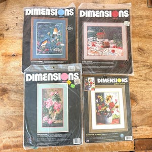 以下が含まれることがあります： Dimensionsブランドのクルーウェル刺繍キット4点。プラスチックパッケージ入り。鳥のいる庭、リンゴの籠がある庭の風景、ピンクのバラのブーケ、ヒマワリを含む色とりどりの花が入ったバケツのプリント画像がそれぞれ描かれています。