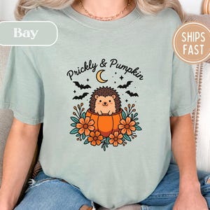 T-shirt with hedgehog in pumpkin and text "Prickly & Pumpkin", "Bay", "Ships Fast".
