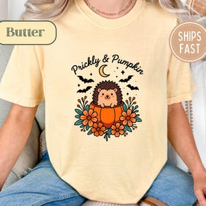 Yellow t-shirt with a "Prickly & Pumpkin" graphic of a hedgehog in a pumpkin.