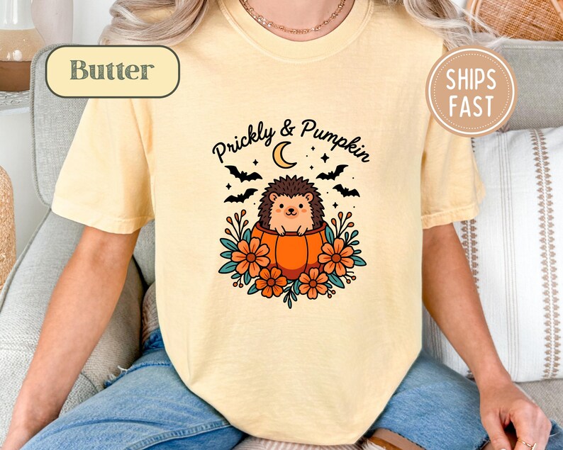 Yellow t-shirt with a "Prickly & Pumpkin" graphic of a hedgehog in a pumpkin.
