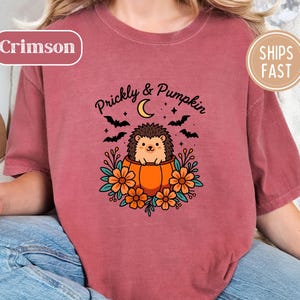 Crimson tee with a Halloween graphic of hedgehog in a pumpkin, "Prickly & Pumpkin" text.