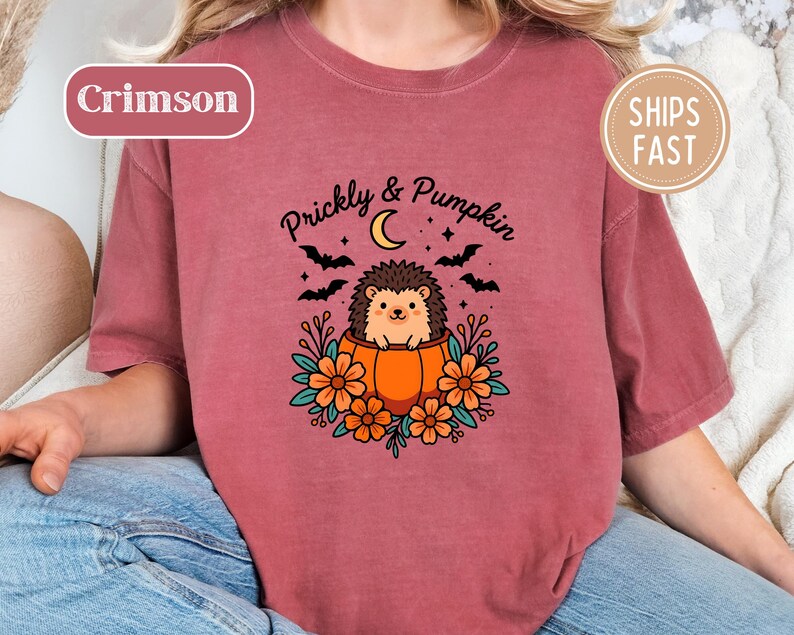Crimson tee with a Halloween graphic of hedgehog in a pumpkin, "Prickly & Pumpkin" text.