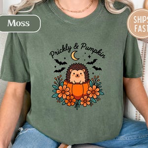 Green t-shirt with "Prickly & Pumpkin" text, a hedgehog, bats, and moon.