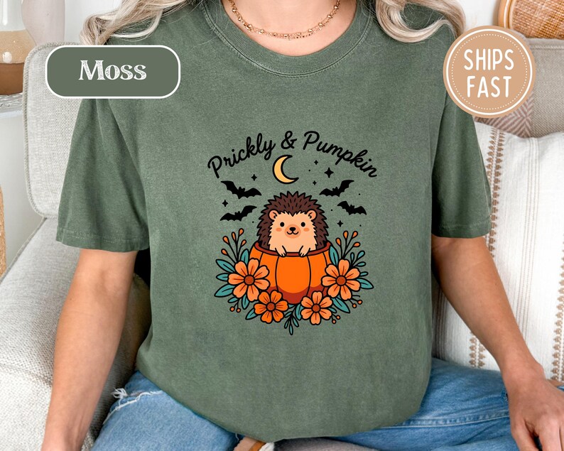 Green t-shirt with "Prickly & Pumpkin" text, a hedgehog, bats, and moon.