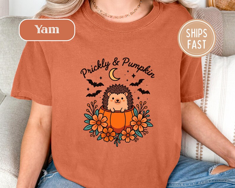 Orange shirt with "Prickly & Pumpkin" text, hedgehog, moon, bats, and flowers.