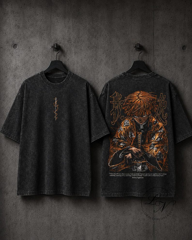 May include: A charcoal grey acid-wash t-shirt featuring a small vertical sword graphic on the front and a large, detailed illustration of an anime character with blonde hair in a patterned orange robe on the back, accompanied by Japanese text.