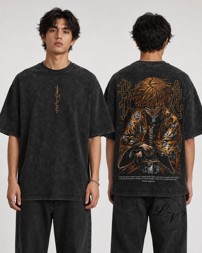 May include: A charcoal grey acid-wash t-shirt featuring a small vertical sword graphic on the front. The back displays a large, detailed orange and black anime character illustration with Japanese kanji and English text at the bottom.