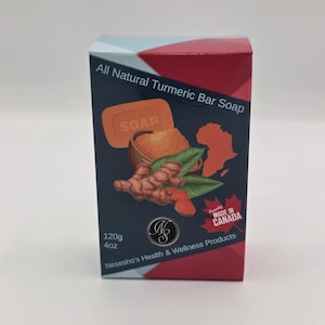 Puede incluir: Una caja rectangular de jabón de cúrcuma All Natural Turmeric Bar Soap con fondo azul oscuro y detalles en rojo y azul claro. El empaque muestra un gráfico de raíz de cúrcuma, un tazón de polvo, una barra de jabón naranja y una hoja de arce roja con el texto Made in Canada. La caja está etiquetada con 120g y 4oz, junto con la marca Nesesho's Health & Wellness Products.