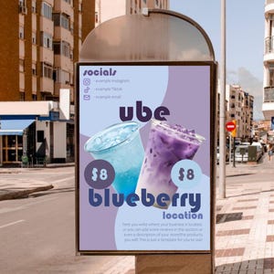 May include: A vertical outdoor advertising sign featuring a light purple and blue background with the text socials, ube, blueberry, and location. Two plastic cups containing blue and purple iced beverages are displayed with price tags of $8.