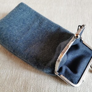 Puede incluir: Un estuche rectangular de fieltro azul con un cierre de boquilla met&aacute;lico de color plateado. El interior del estuche est&aacute; forrado con una tela azul oscuro y el exterior tiene una superficie suave y texturizada propia del fieltro.