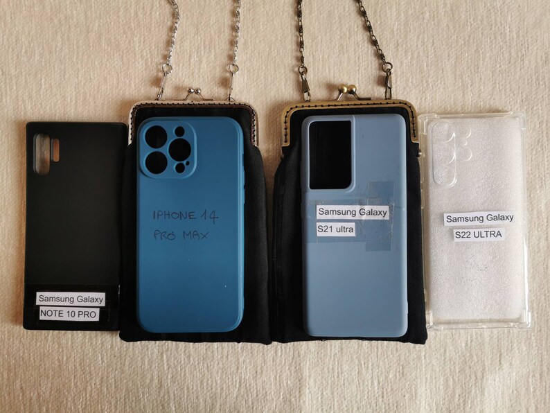 Może przedstawiać: Kolekcja czterech etui na telefony: czarne etui Samsung Galaxy Note 10 Pro, niebieskie etui iPhone 14 Pro Max w czarnym pokrowcu z łańcuszkiem, jasnoniebieskie etui Samsung Galaxy S21 Ultra w czarnym pokrowcu z łańcuszkiem oraz przezroczyste etui Samsung Galaxy S22 Ultra.