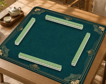 Puede incluir: Un tapete de mahjong cuadrado de color verde oscuro con detalles dorados en forma de abanico en las esquinas y finas líneas doradas en los bordes. Cuatro filas de fichas de mahjong verde claro están dispuestas en formación cuadrada.