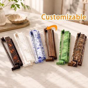 May include: A collection of six rectangular display stands with various finishes including tortoiseshell, white marble, blue and white floral, wood grain, green marble, and brown marble. The text Customizable is visible above the stands.