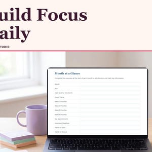 May include: A digital planner displayed on a laptop screen titled Month at a Glance with fields for goals, priorities, and habits. The image includes the text Build Focus Daily and Ankora Studio, a purple mug, and pastel stationery.