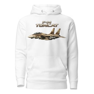 May include: A white hooded sweatshirt featuring a graphic of an F-14 Tomcat fighter jet in a tan and brown camouflage pattern. The text F-14 TOMCAT is printed in a bold, metallic-toned font above the aircraft illustration on the front chest.