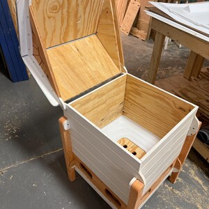 Pu&ograve; includere: Un contenitore per compost in legno con coperchio incernierato. Il contenitore &egrave; costruito in legno naturale e verniciato di bianco con gambe in legno a vista. L'interno presenta una base in plastica bianca con fori di drenaggio.