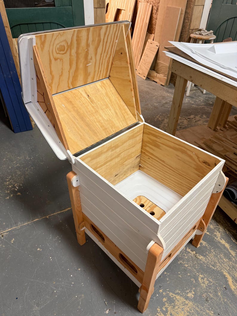 Pu&ograve; includere: Un contenitore per compost in legno con coperchio incernierato. Il contenitore &egrave; costruito in legno naturale e verniciato di bianco con gambe in legno a vista. L'interno presenta una base in plastica bianca con fori di drenaggio.