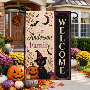 Puede incluir: Una bandera de jardín rectangular con una sección color crema con el texto The Anderson Family, una luna creciente, murciélagos y un gato negro con un sombrero de bruja morado junto a una calabaza. Un panel negro vertical muestra la palabra WELCOME.