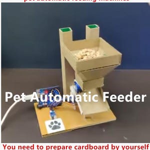 May include: An automatic pet feeder prototype constructed from cardboard with an electronic circuit board, wiring, and a white power cable. The device features a hopper for food, a chute, and a base with a paw print graphic and the text Pet Automatic Feeder.