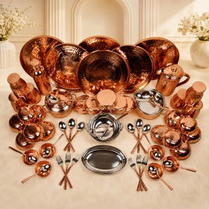 May include: A large collection of hammered copper kitchenware including various bowls, plates, cups, and serving utensils. The set features metallic copper exteriors with reflective surfaces, some items have silver-toned interiors and matching cutlery.
