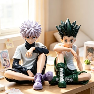 May include: Two anime-style character figures sitting on a desk. The left figure has spiky white hair, a white shirt over a black long-sleeve top, black shorts, and purple shoes. The right figure has spiky black hair, a white tank top, and green shorts.