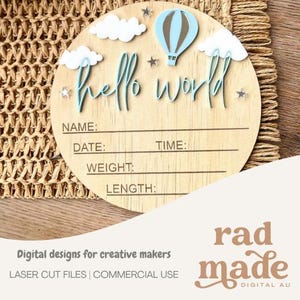 Op de afbeelding: Een rond houten geboorteaankondigingsbord met de tekst hello world in blauw schrift. Het ontwerp bevat witte wolken, een blauwe heteluchtballon en kleine zilveren sterren. Daaronder staan lijnen voor naam, datum, tijd, gewicht en lengte.