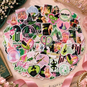 Puede incluir: Una colección de pegatinas variadas con imágenes y texto relacionados con el musical Wicked, incluyendo personajes, corazones, naipes y logotipos en tonos rosa, verde y negro, dispuestos en un grupo circular sobre una superficie plana.