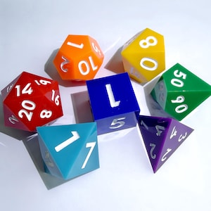 May include: A set of seven multi-colored polyhedral dice including red, orange, yellow, green, blue, purple, and teal pieces. Each die features white engraved numbers on its various geometric faces, including a cube, a pyramid, and an icosahedron.