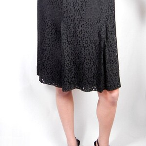 May include: A black lace dress with a flared skirt and a pair of black heeled sandals with buckles.