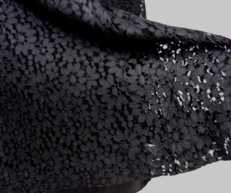 May include: Black lace fabric with a floral pattern.