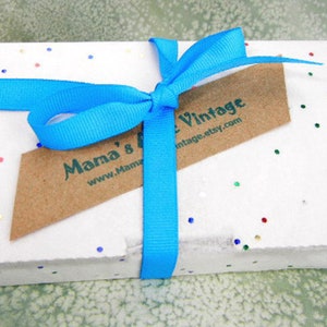 May include: A white gift box with a blue ribbon and a brown tag that says "Mama's Vintage www.MamaVintage.etsy.com". The box is covered in small, colorful confetti.