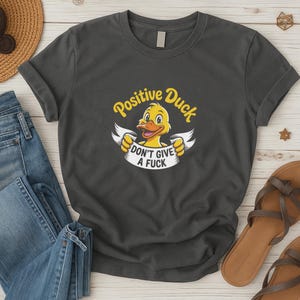 ポジティブダックTシャツ - 「Don't Give A Fuck」バナー付きおもしろ漫画ダックシャツ - 皮肉なユーモアグラフィックTシャツ