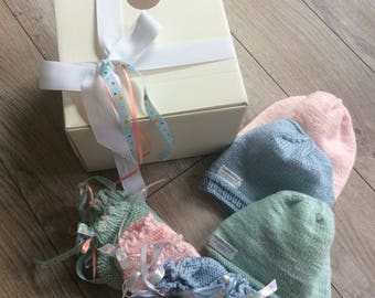 One dozen hand knitted, hand made baby gift set. baby- new born cap, and booties decorated with ribbon in a gift bag