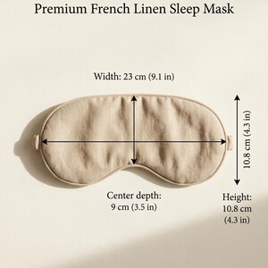 May include: A beige sleep mask with a size guide featuring the text: SIZE GUIDE: Premium French Linen Sleep Mask. The width is 9.1 inches, the height is 4.3 inches, and the center depth is 3.5 inches. The mask has a rounded, contoured shape.