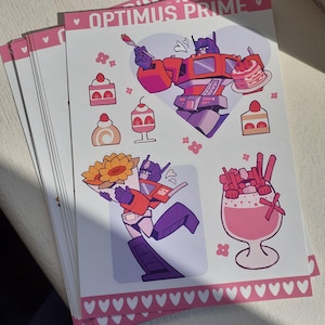 Puede incluir: Una hoja de pegatinas con Optimus Prime en una paleta de colores rosa y morado. El diseño incluye a Optimus Prime sosteniendo un pastel y un ramo de girasoles, junto a ilustraciones de postres, todo enmarcado por bordes de corazones rosas.