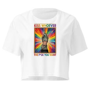 Könnte beinhalten: Weißes Crop-Top mit einer Grafik der Freiheitsstatue vor einem Regenbogenhintergrund. Der Text "KISS WHOEVER" steht über dem Bild und "THE F*CK YOU WANT" darunter.